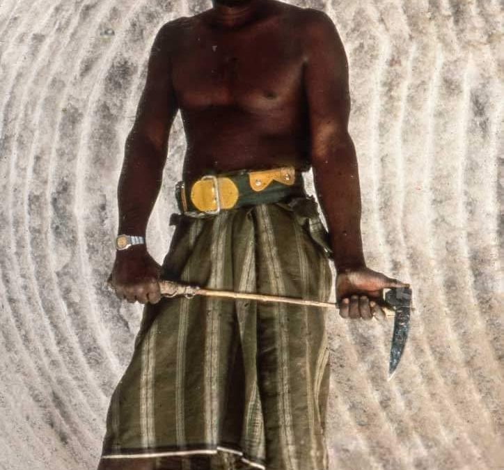 صورة لرجل يحمل معول الملح في منجم الملح القديم في مدينة شبوة القديمة. تصوير لين أبركرومبي عام 1985م