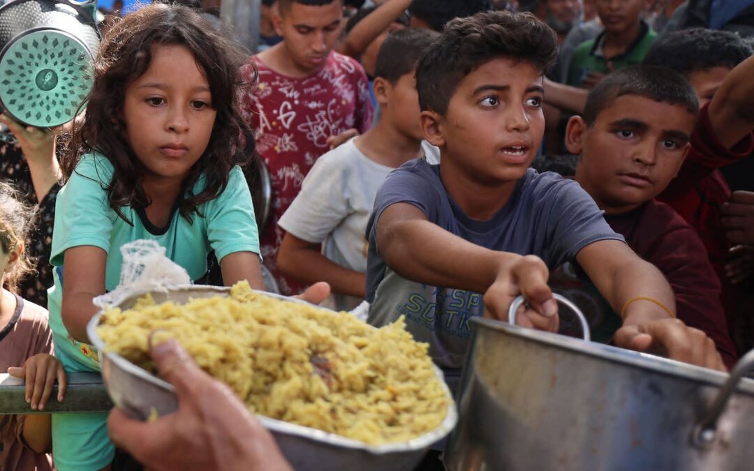 أطفال فلسطينيون في قطاع غزة يتلقون مساعدات غذائية من مطبخ خيري